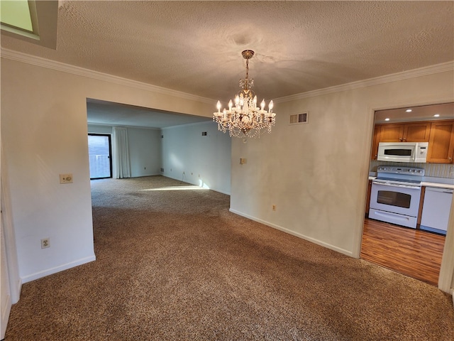 unfurnished dining area featuring crown molding, a textured ceiling, a notable chandelier, and carpet flooring