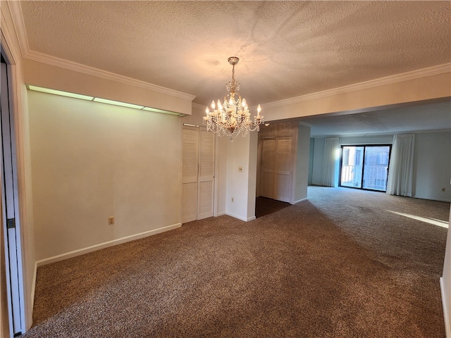 spare room featuring a notable chandelier, a textured ceiling, ornamental molding, and dark carpet