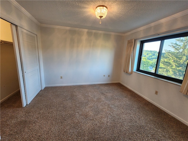 unfurnished bedroom with ornamental molding, carpet, a textured ceiling, and a closet