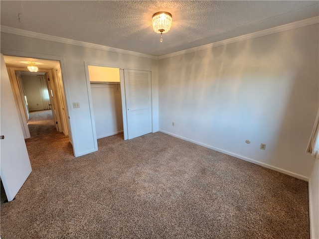 unfurnished bedroom featuring a textured ceiling, crown molding, carpet floors, and a closet