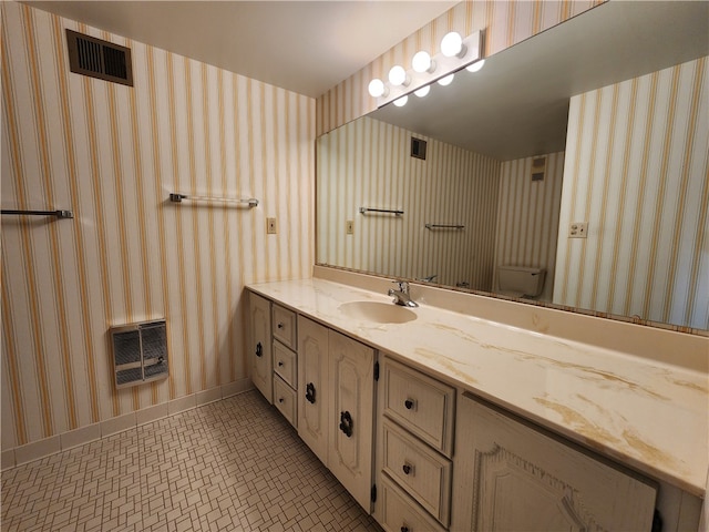 bathroom with vanity, toilet, tile patterned floors, and heating unit