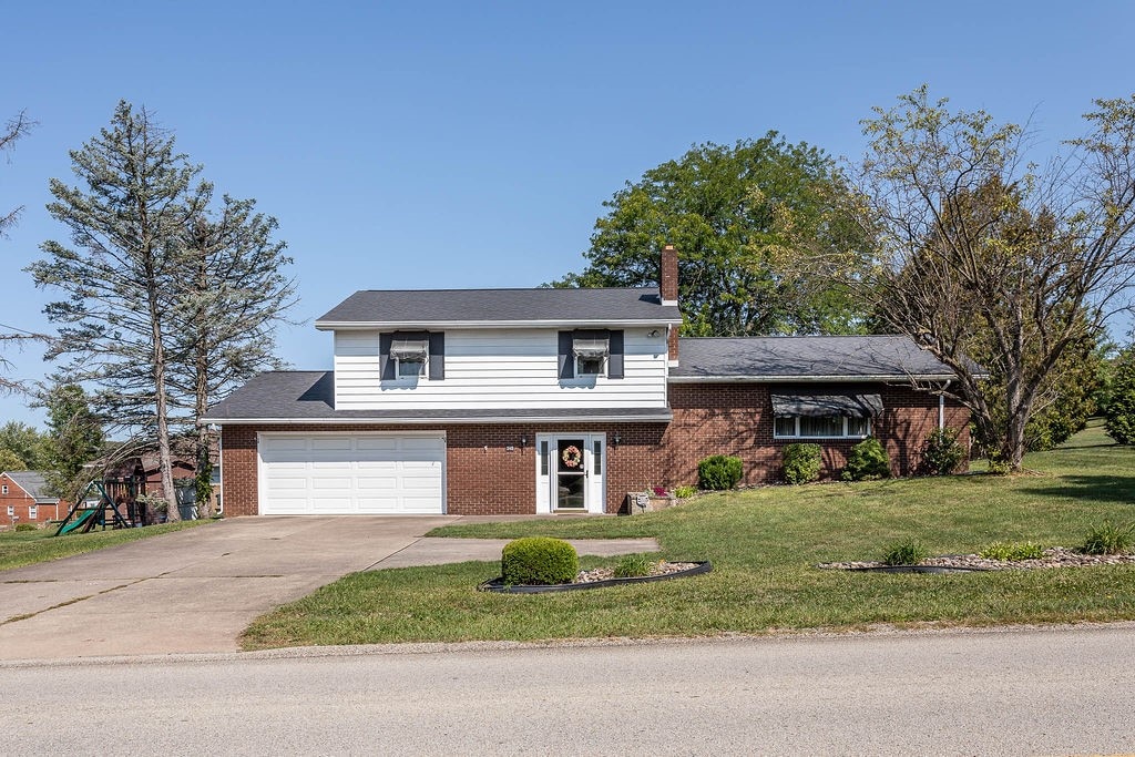 view of front of house with a garage and a front lawn