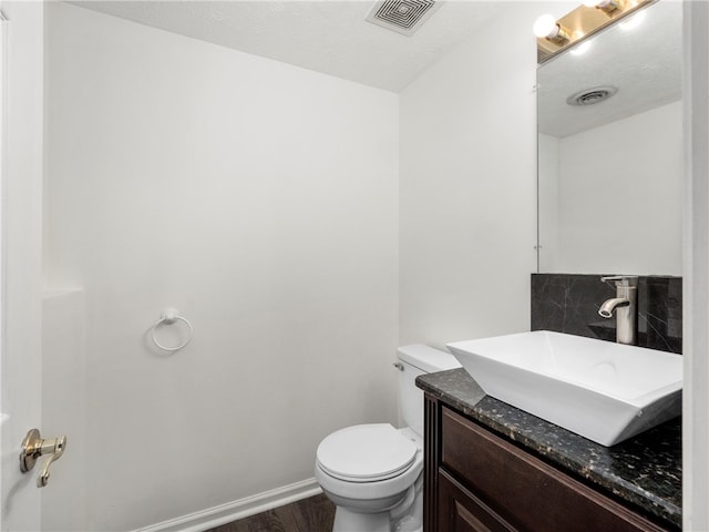 bathroom with vanity, toilet, and hardwood / wood-style floors