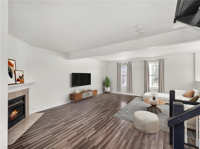 living room featuring hardwood / wood-style flooring, a textured ceiling, and a tile fireplace