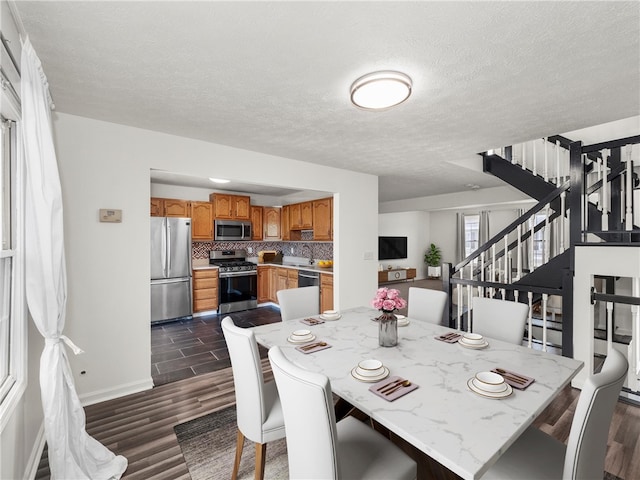 dining area with a textured ceiling and dark hardwood / wood-style floors