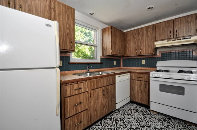 kitchen featuring sink, white appliances, and tasteful backsplash