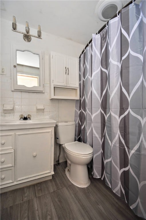 bathroom with a shower with curtain, toilet, hardwood / wood-style flooring, and vanity