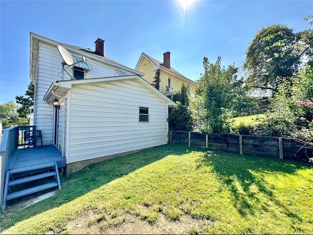 rear view of property featuring a yard and a deck