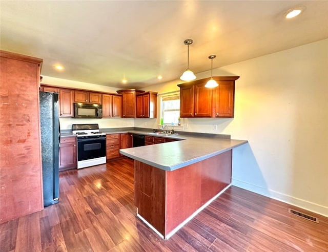 kitchen with black appliances, pendant lighting, dark hardwood / wood-style floors, and kitchen peninsula