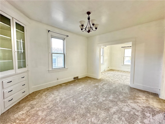 interior space featuring ornamental molding, light colored carpet, and a notable chandelier