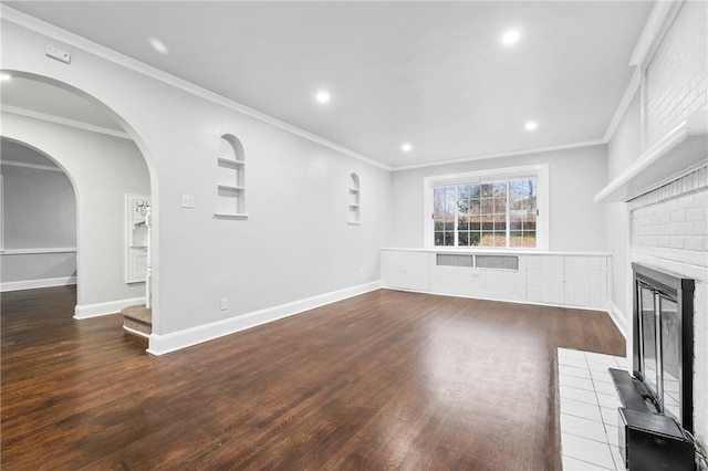 unfurnished living room featuring ornamental molding, hardwood / wood-style flooring, and a brick fireplace