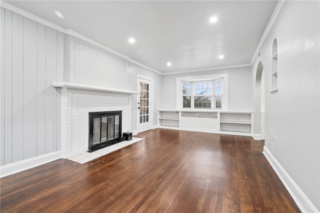 unfurnished living room with ornamental molding, hardwood / wood-style flooring, and a brick fireplace