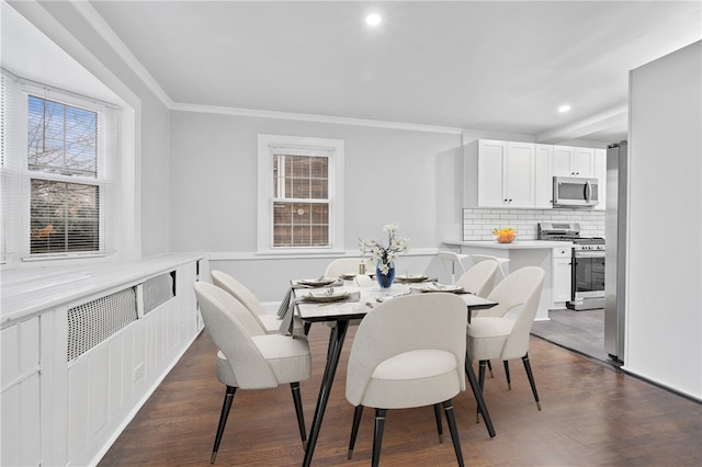 dining space featuring ornamental molding and dark hardwood / wood-style flooring