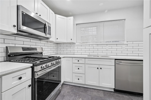 kitchen featuring appliances with stainless steel finishes, white cabinetry, and decorative backsplash