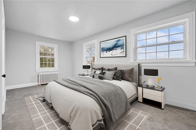 carpeted bedroom featuring radiator heating unit and multiple windows