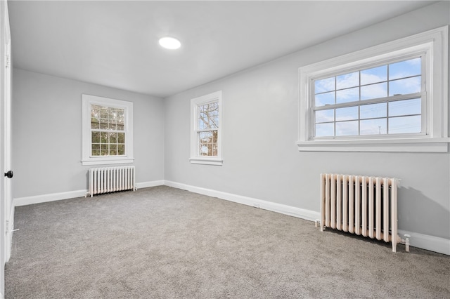 unfurnished room with radiator and carpet flooring