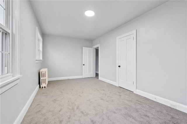 carpeted empty room with radiator