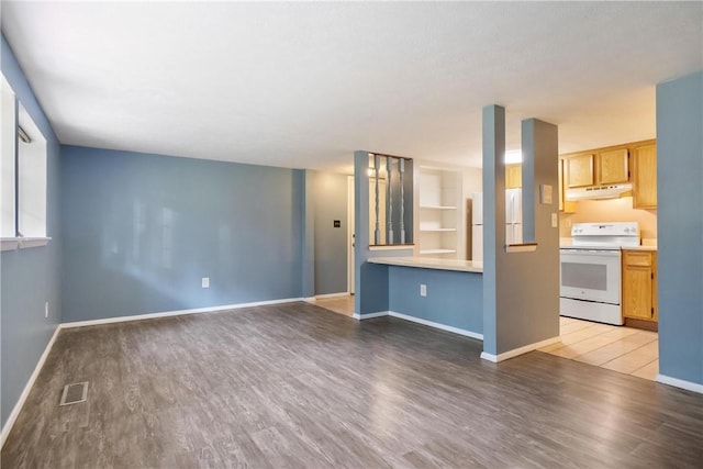 unfurnished living room with visible vents, light wood-style flooring, and baseboards