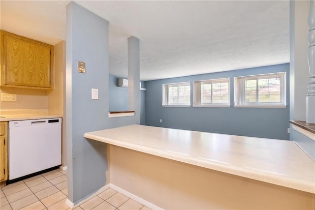 kitchen with light countertops, dishwasher, baseboards, and light tile patterned floors