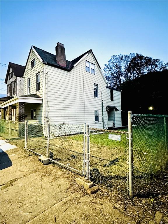 121 Watkins Ave, Wilmerding, PA 15148 - view of home's exterior with a chimney and fence