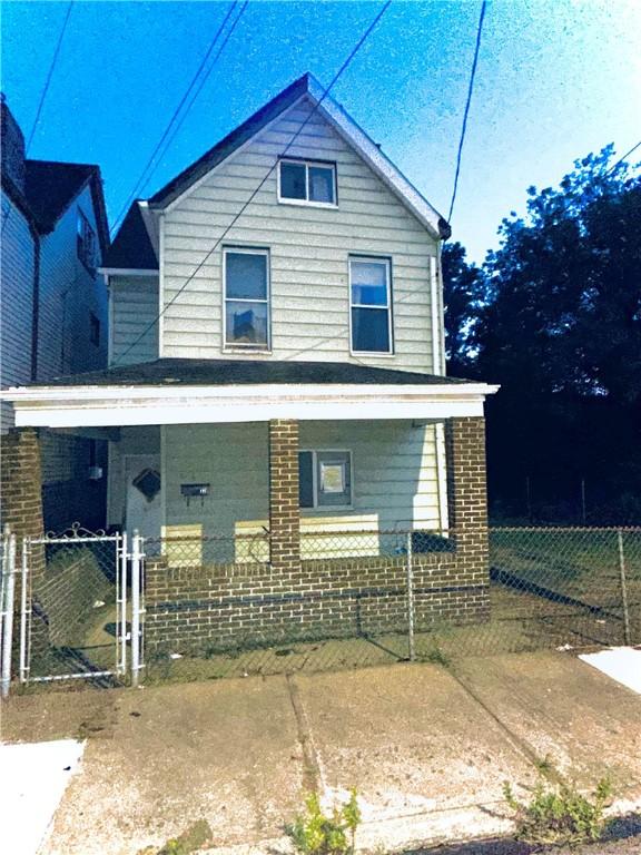 121 Watkins Ave, Wilmerding, PA 15148 - view of front of property featuring covered porch, fence, and brick siding