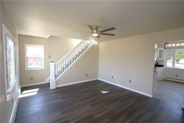 unfurnished living room with a baseboard radiator, dark hardwood / wood-style flooring, ceiling fan, and a wealth of natural light