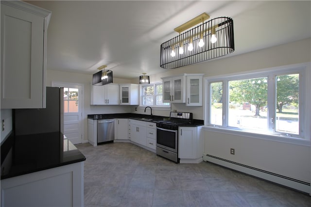 kitchen with appliances with stainless steel finishes, hanging light fixtures, white cabinetry, and a baseboard radiator