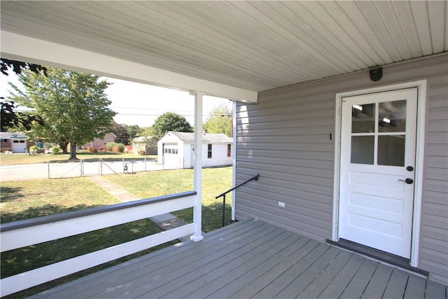 wooden deck featuring a storage unit and a yard