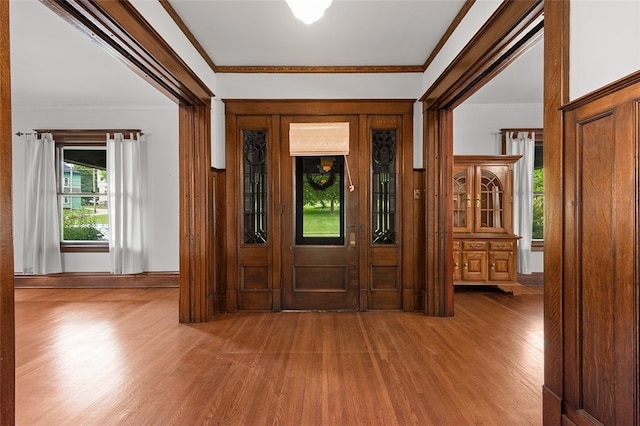 foyer with ornamental molding and hardwood / wood-style flooring