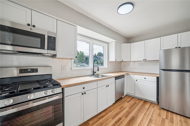 kitchen featuring appliances with stainless steel finishes, white cabinetry, and sink