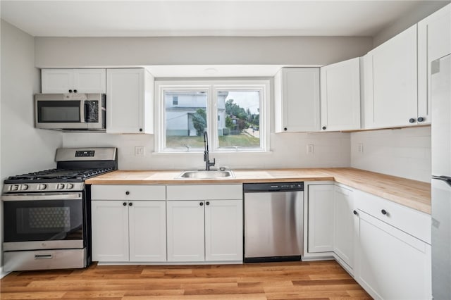 kitchen featuring light hardwood / wood-style flooring, stainless steel appliances, sink, and white cabinets