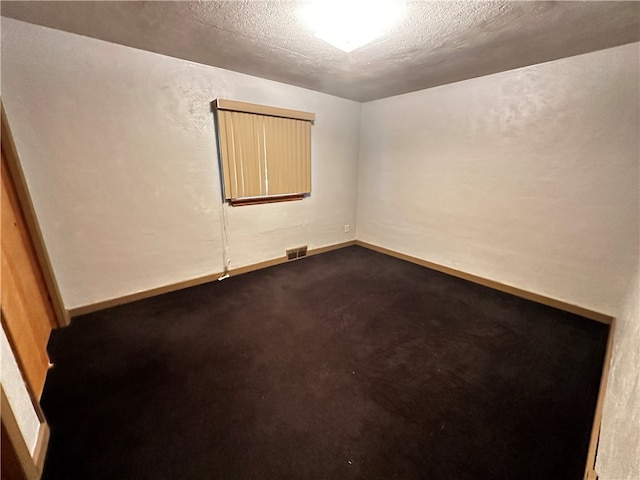 carpeted empty room with a textured ceiling