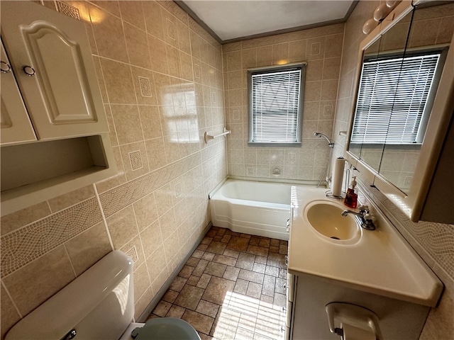 bathroom with a wealth of natural light, tile walls, toilet, and vanity