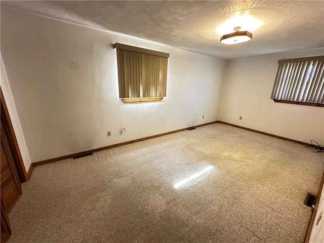 carpeted empty room featuring a textured ceiling