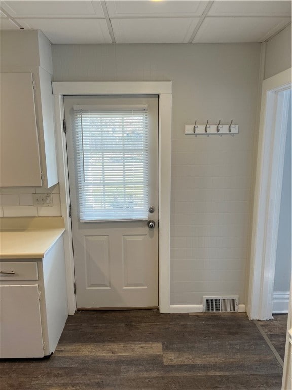 doorway featuring dark hardwood / wood-style flooring and a paneled ceiling