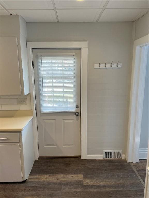 entryway with dark wood finished floors, visible vents, and a drop ceiling