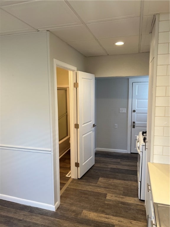 corridor featuring dark hardwood / wood-style flooring and a drop ceiling