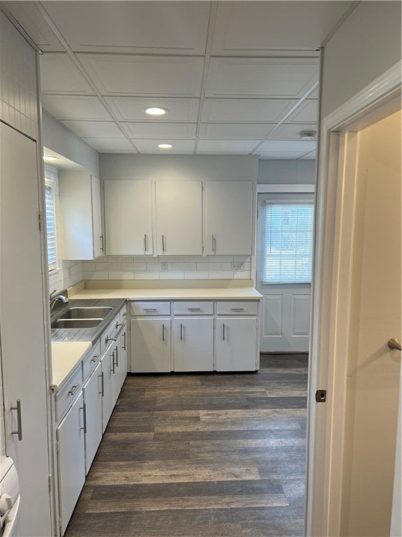 kitchen with dark wood-type flooring, white cabinetry, sink, and tasteful backsplash