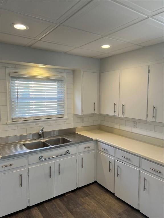 kitchen with tasteful backsplash, dark wood-style flooring, white cabinetry, and a sink