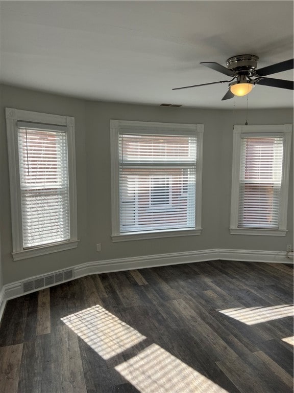 empty room with dark wood-type flooring and ceiling fan