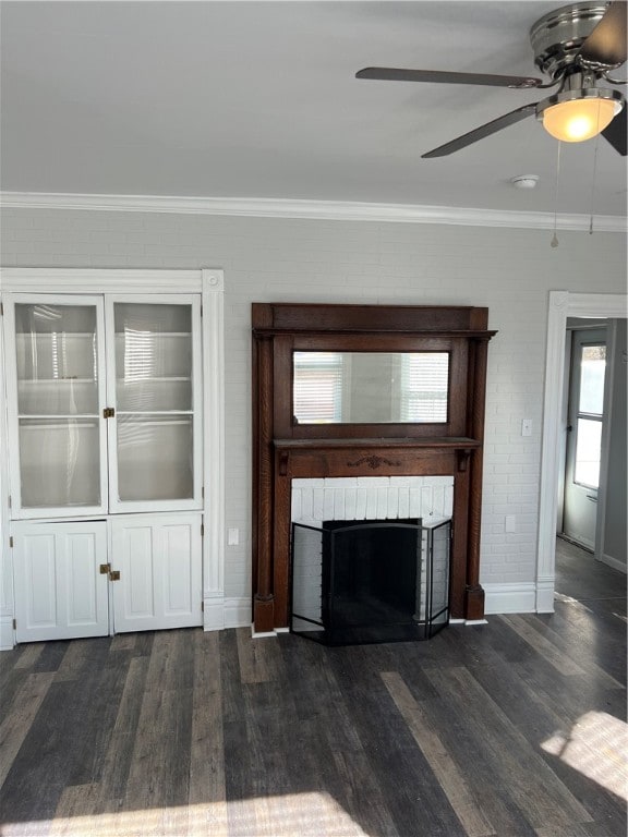 unfurnished living room with crown molding, ceiling fan, dark hardwood / wood-style flooring, and a fireplace