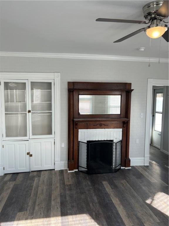 unfurnished living room with a fireplace, crown molding, baseboards, and wood finished floors