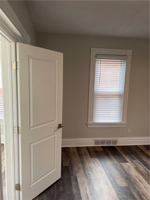 unfurnished room featuring dark wood-type flooring