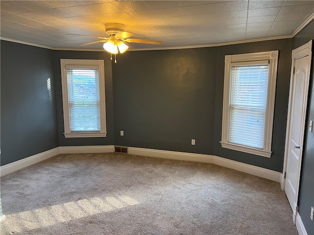 empty room with carpet flooring, ceiling fan, and ornamental molding