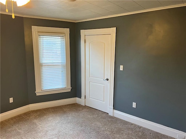 unfurnished room with ornamental molding, baseboards, and carpet floors