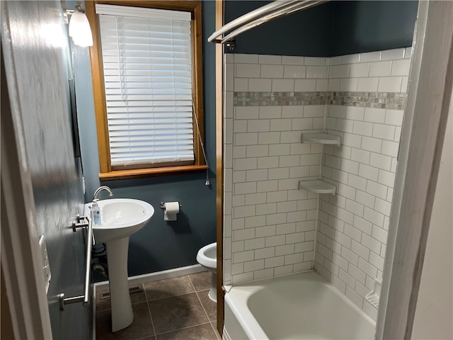 bathroom featuring toilet, tile patterned floors, and tiled shower / bath