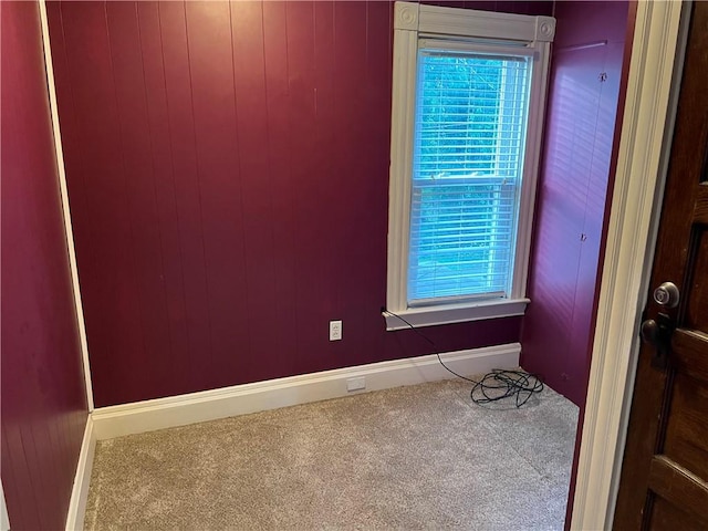 unfurnished room with baseboards, plenty of natural light, and carpet