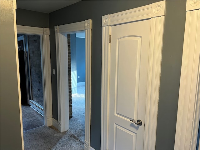 hall featuring a baseboard heating unit and dark colored carpet