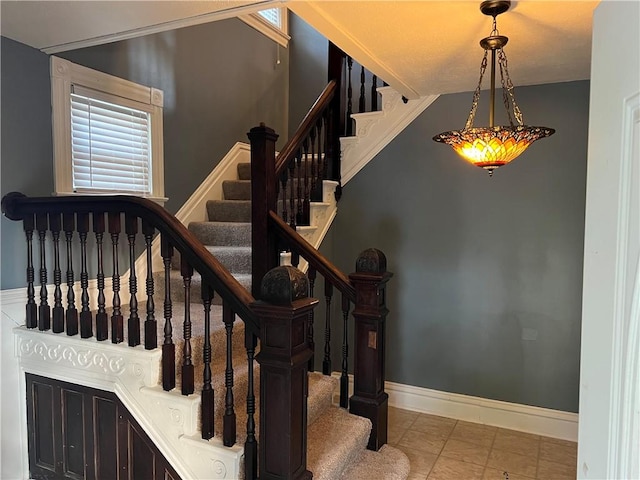 stairway with baseboards and tile patterned flooring