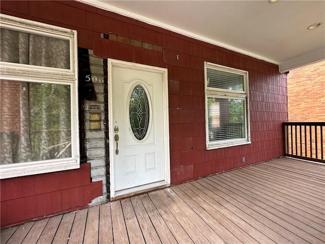 view of exterior entry featuring covered porch